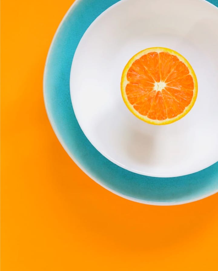 Half of orange on blue plate